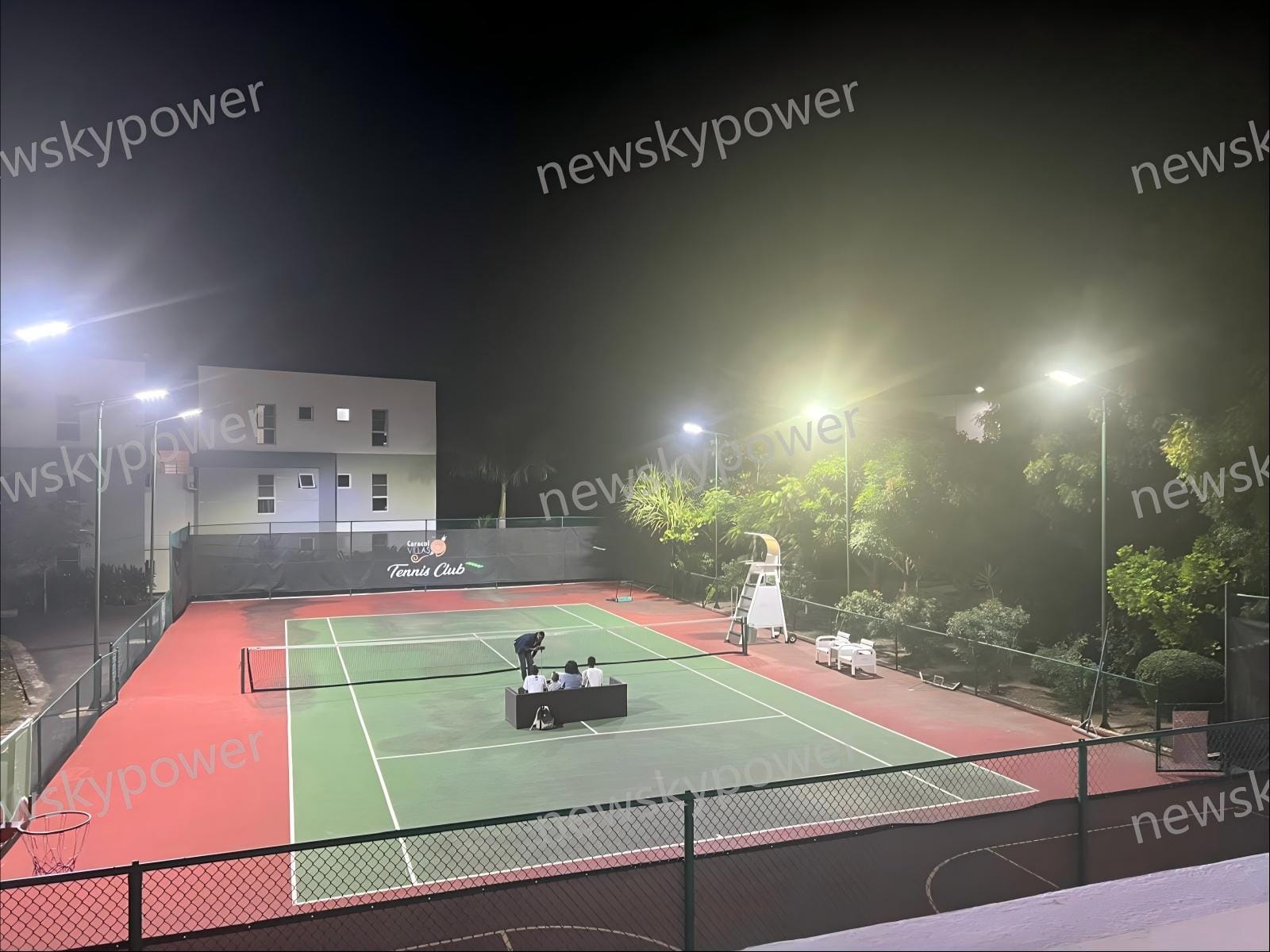 Completed NZ-150W solar street light installation providing bright illumination for the tennis court at night.