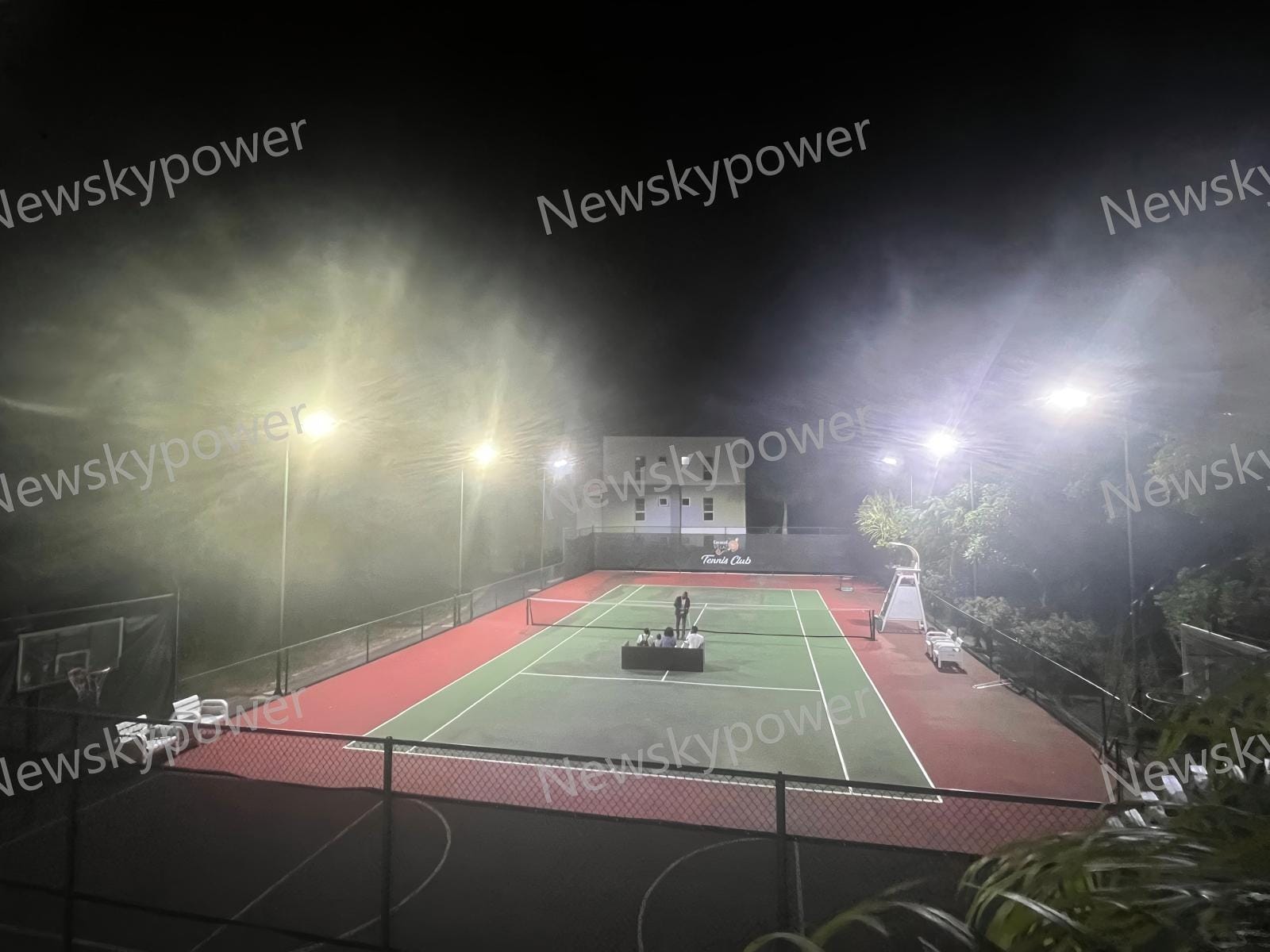 NZ-150W solar street lights installed on 8-meter poles around the tennis court.