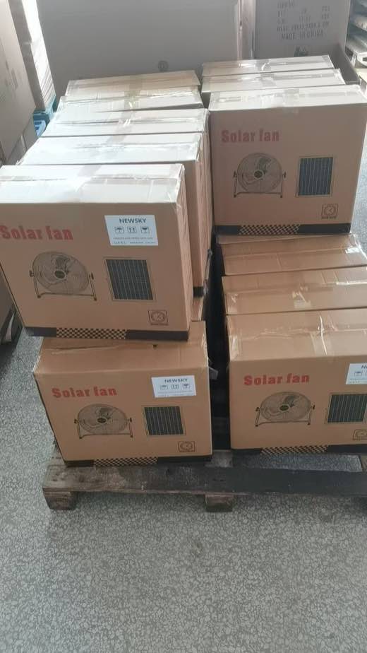 Real shipment image — 118F portable solar-fan cartons staged on wooden pallets