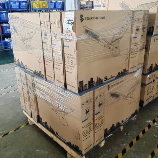Real shipment image — MJ-S5500 Pro solar street-light cartons secured in stretch wrap on a pallet.