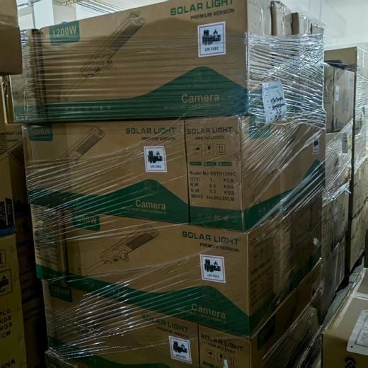 Real shipment image — MJ-SSTH1200C camera solar street-light cartons secured as a pallet group