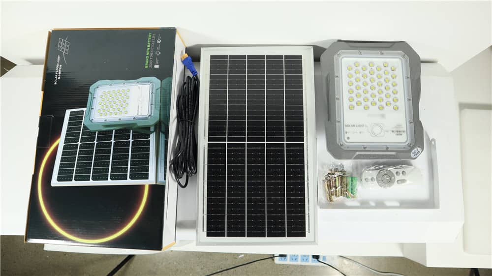 BW solar flood light panel and supplied accessories laid out beside packaging