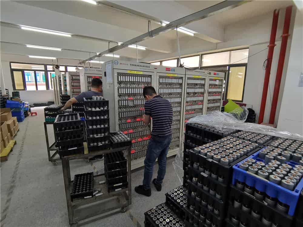 Flood lights arranged on racks in a factory testing area