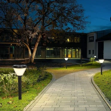 Fixed solar garden lights lining a paved path at night