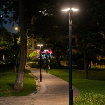 Pole-mounted garden light beside a landscaped pathway at night