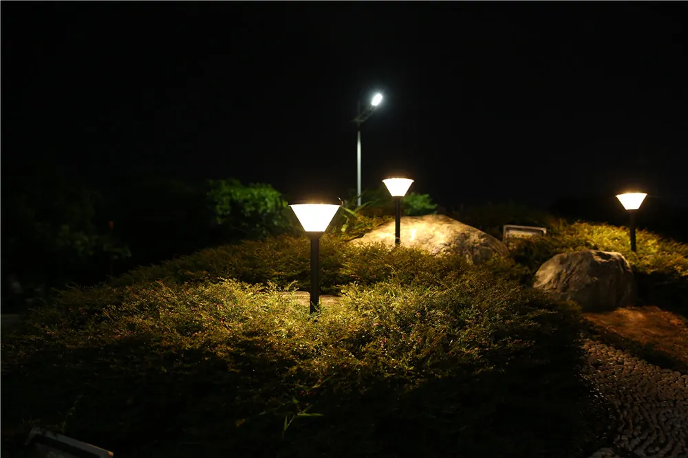 Low solar stake lights among planting with other lighting in the background
