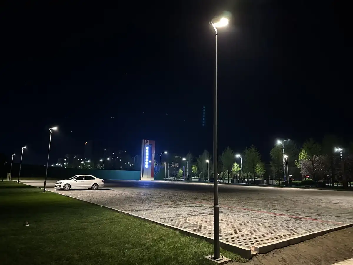 Pole-mounted courtyard lights around a paved area at night