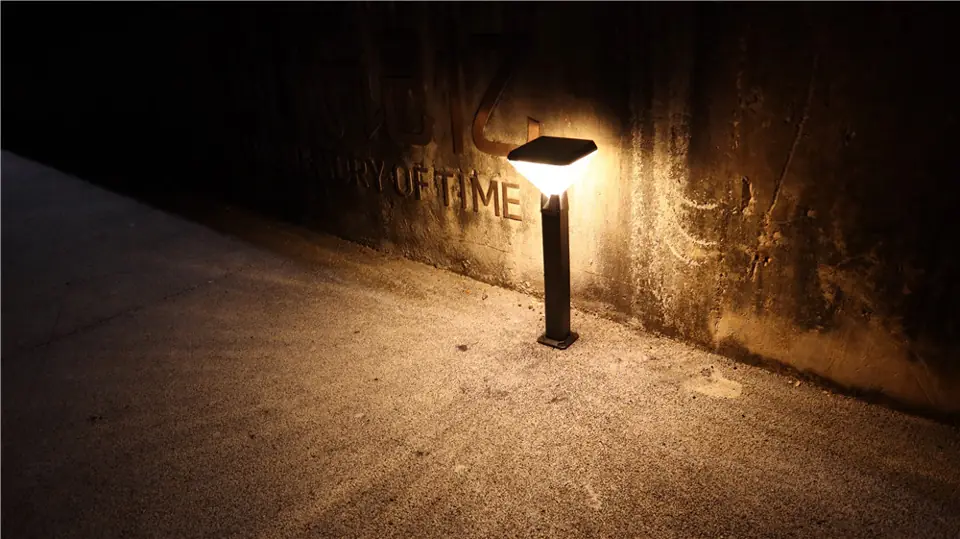Low landscape light near a wall and path at night