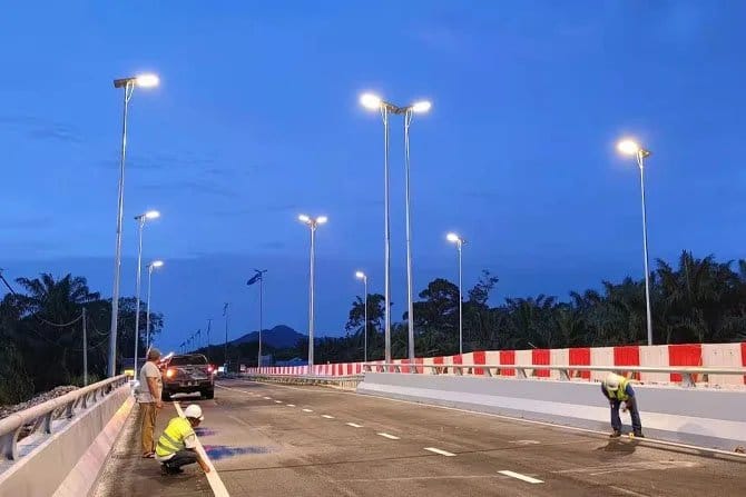 Solar street lights illuminating a roadway at dusk