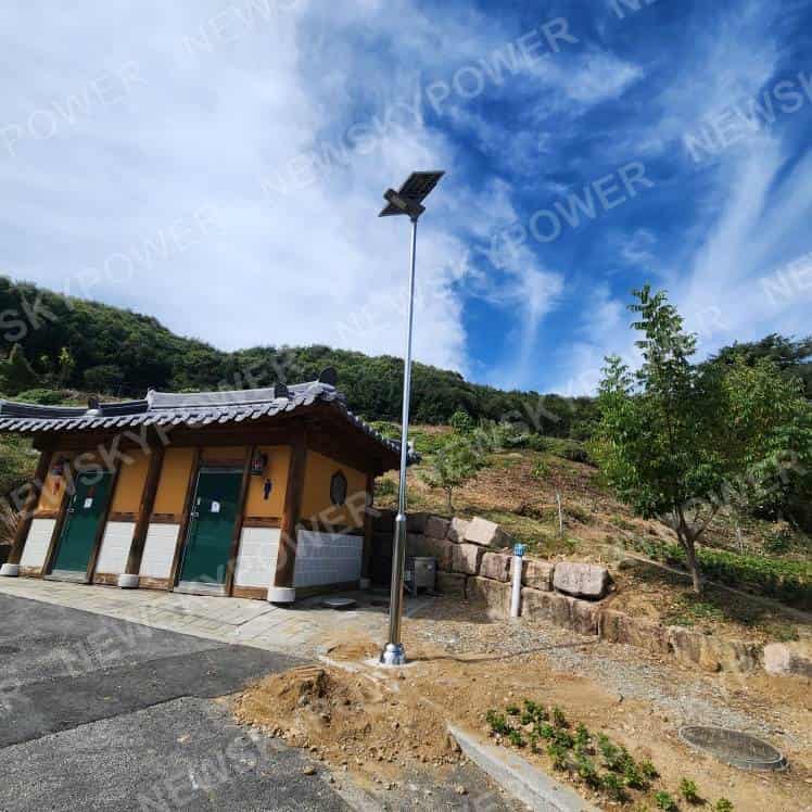 Solar street light installed beside a building and paved access area